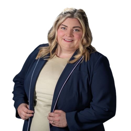 A woman with blonde hair wearing a beige top and navy blazer, smiling at the camera against a white background.